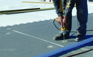What are the benefits in using a fully adhered single-ply roofing system?